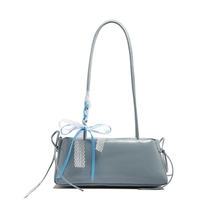 Bolso de hombro azul en cuero sintético con lazo de encaje y correas en fondo blanco