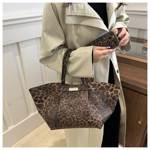 Chic leopard print tote bag with gold metal hardware and matching phone case detail