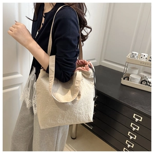 Detail of beige textured tote bag with pink drawstring lining and dual handles