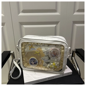 Detail view of a white PU leather ita bag with a clear PVC window and anime badges