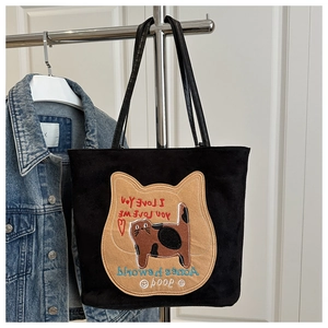 Close-up of black suede tote bag featuring detailed cat embroidery and heart patterns