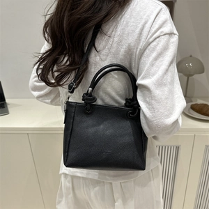 Fashionable black pebbled leather square crossbody bag with unique knot handle design