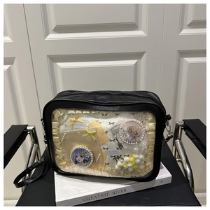 Detail of black ita bag featuring transparent window and delicate lace trim ruffles