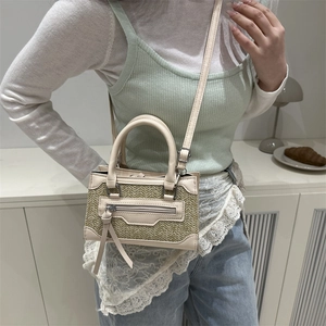 Borsa a mano minimalista in paglia e pelle bianco crema indossata da modella