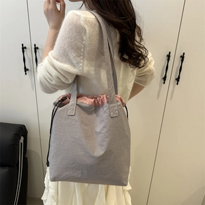 Minimalist light purple drawstring tote bag with pink interior in a lifestyle setting