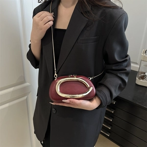 Fashionable burgundy glossy leather crossbody bag with a bold gold C-buckle and chain strap
