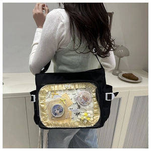 Détail du sac ita noir avec fenêtre transparente montrant des badges et rubans