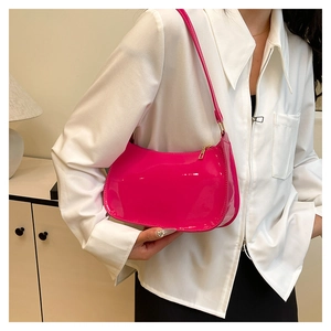 Glossy pink patent leather baguette bag shown as a shoulder carry with gold zipper