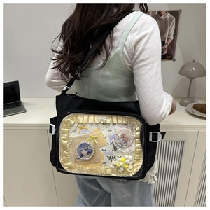 Détail du sac ita en toile noire avec fenêtre transparente et bordure en dentelle jaune