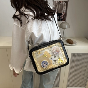 Black rectangular Ita Bag with transparent window and anime character pins on a model