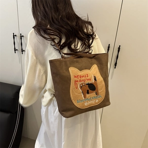 Brown felt tote bag with cat embroidery and shoulder straps in a minimalist setting