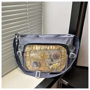 Détail du sac ita bleu clair avec fenêtre transparente et décorations de badges