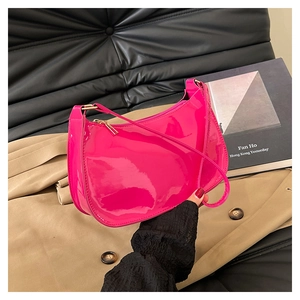Detail of high-gloss pink patent leather half-moon bag with golden zipper hardware