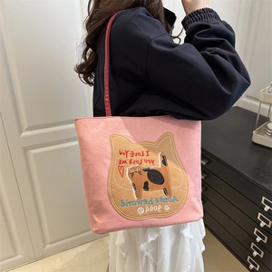 Pink canvas tote bag featuring a cat patch with red straps on a shoulder-carry model