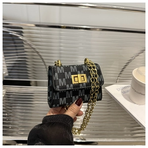 Close-up of black crossbody bag with M-letter print and golden metal chain strap