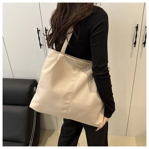 Side view of beige nylon tote bag on shoulder showing large capacity and fashion text
