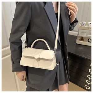 Detail of cream envelope handbag with V-shaped stitching and adjustable crossbody strap