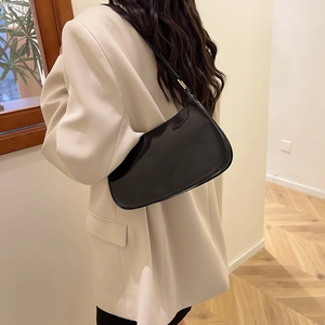 Chic black patent leather underarm bag with high-gloss finish and crescent shape