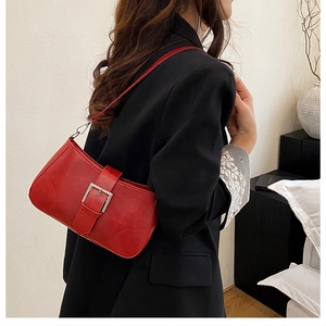 Detailed view of red matte PU leather underarm bag with silver buckle on a model