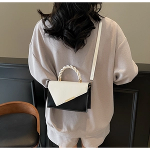 Rear view of a model wearing the black and white contrast small square crossbody bag