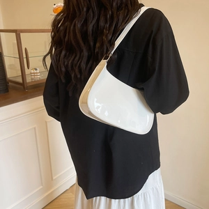 Minimalist white patent leather crescent hobo bag for women worn on the shoulder