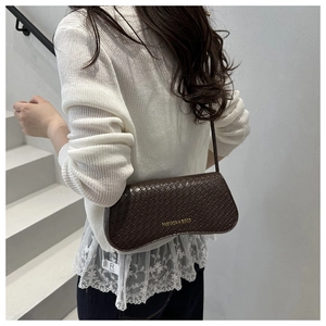 Brown baguette bag with woven leather texture and gold text shown on a shoulder