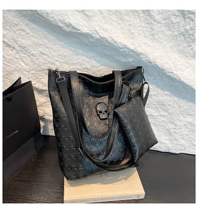 Close-up of black punk tote bag with skull embossing and rhinestone skull metal hardware