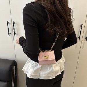 Pink mini square crossbody bag with gold chain strap and vintage metal lock on black top