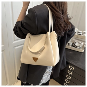 Detail of off-white leather shoulder bag with semicircular handle on an elegant model