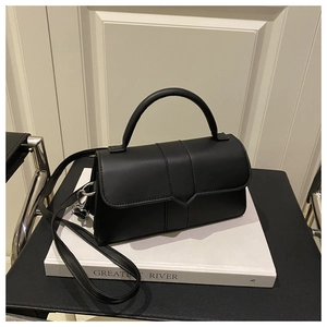 Detail shot of black minimalist square crossbody bag with matte leather and silver hardware