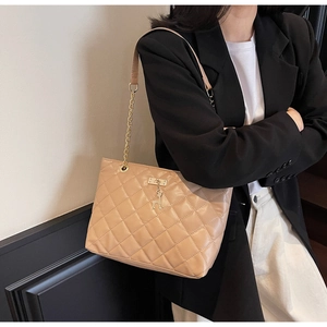 Close-up of quilted khaki faux leather bag with gold deer pendant and chain strap