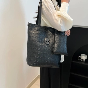 Fashionable black skull embossed tote bag set with rhinestone metal skull detail