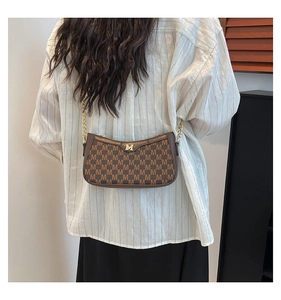 Close-up of vintage brown shoulder bag with gold M hardware and monogram texture