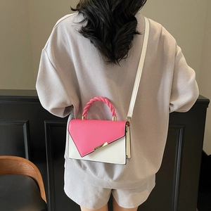 Pink and white patchwork shoulder bag with a woven handle shown on a model