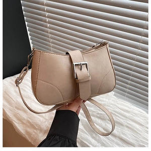 Detail of beige faux leather underarm bag with silver buckle and textured grain