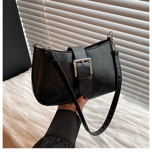 Close-up of black PU leather crescent bag featuring a silver buckle and adjustable strap