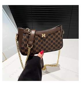 Detail of vintage brown monogram bag featuring gold metal M logo and chain strap