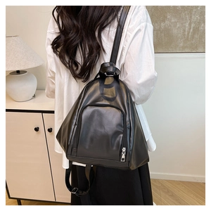 Rear view of woman wearing a minimalist black PU leather backpack in a home setting