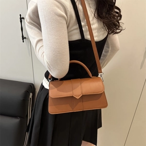 Brown vintage square handbag with detachable strap shown on model for 2025 spring style