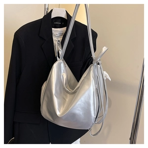 Detail of silver metallic tote bag featuring liquid gloss texture and sleek zipper side