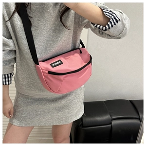 Détail du sac demi-lune en nylon rose avec bandoulière noire réglable et logo
