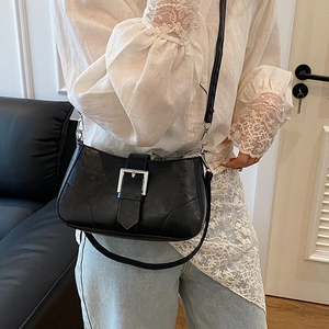 Retro black leather square crossbody bag with silver buckle worn on model for daily style