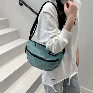 Sac bandoulière demi-lune vert clair minimaliste avec sangle réglable et étiquette mode