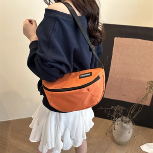 Sac bandoulière demi-lune en toile orange vif avec sangle réglable et étiquette