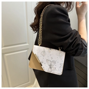 Détail du sac bandoulière à motifs papillons, design bicolore et chaîne dorée
