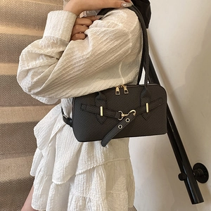 Chic black crocodile embossed PU leather pillow bag with gold hardware worn by a model