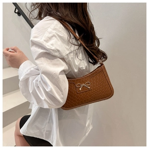 Detail of vintage brown crescent bag with woven texture and silver bow buckle
