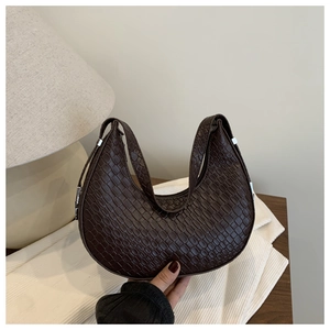 Detailed view of dark brown crescent bag featuring elegant crocodile pattern and silver hardware