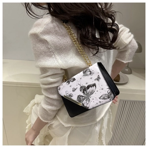 Détail du petit sac carré avec rabat imprimé papillon et bandoulière chaîne dorée