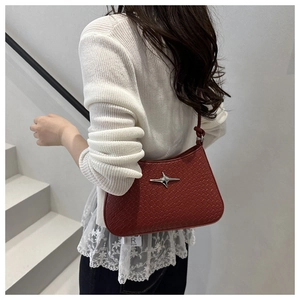 Détail du sac hobo rouge avec texture tissée et ornement en métal étoile argentée à l'épaule